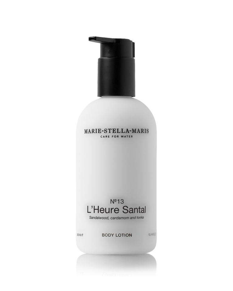 Marie-Stella-Maris Body Lotion in No.13 L’Heure Santal, presented in a white bottle with a black pump. The signature fragrance features notes of sandalwood, cardamom and tonka, photographed against a clean white background.