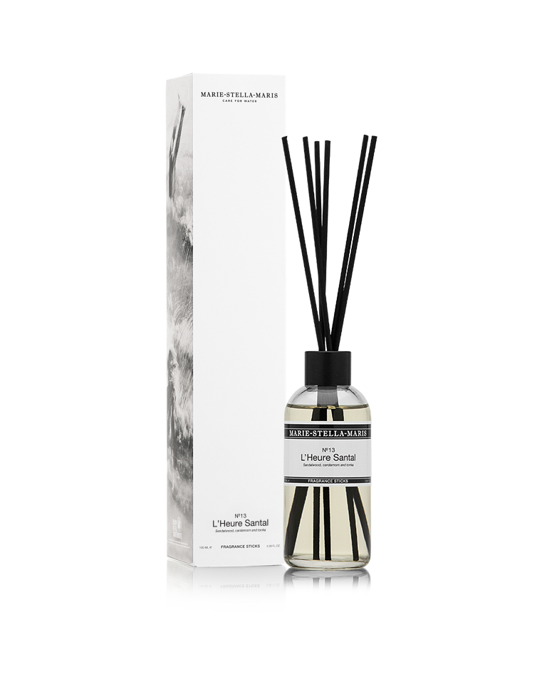 Marie-Stella-Maris Fragrance Sticks in No.13 L’Heure Santal, presented in a clear glass bottle with black fragrance reeds alongside its white product box. The signature fragrance features notes of sandalwood, cardamom and tonka, photographed against a clean white background.