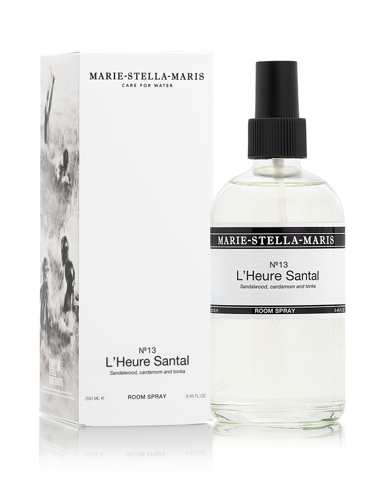Marie-Stella-Maris Room Spray in No.13 L’Heure Santal, presented in a clear glass spray bottle with a black spray cap alongside its white product box. The signature fragrance features notes of sandalwood, cardamom and tonka, photographed against a clean white background.