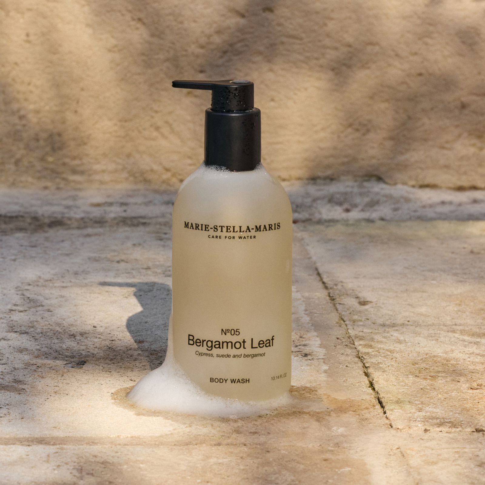 Marie-Stella-Maris No.05 Bergamot Leaf limited edition summer scent body wash 300 ml, surrounded by soft foam and displayed in a warm, sunlit setting, highlighting fragrance notes of cypress, suede, and bergamot.