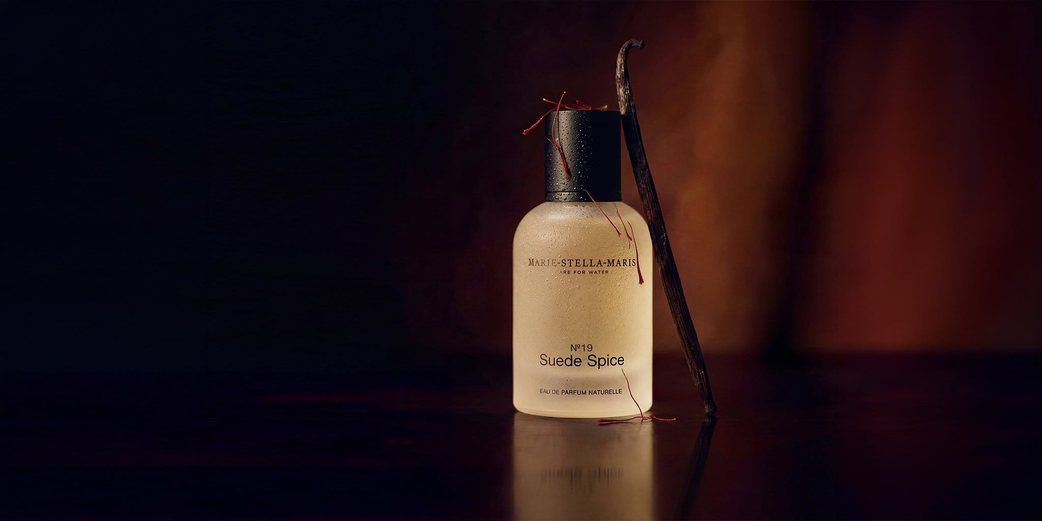 Marie-Stella-Maris suede spice perfume with scent notes in background showing vanilla, suede, and saffron.