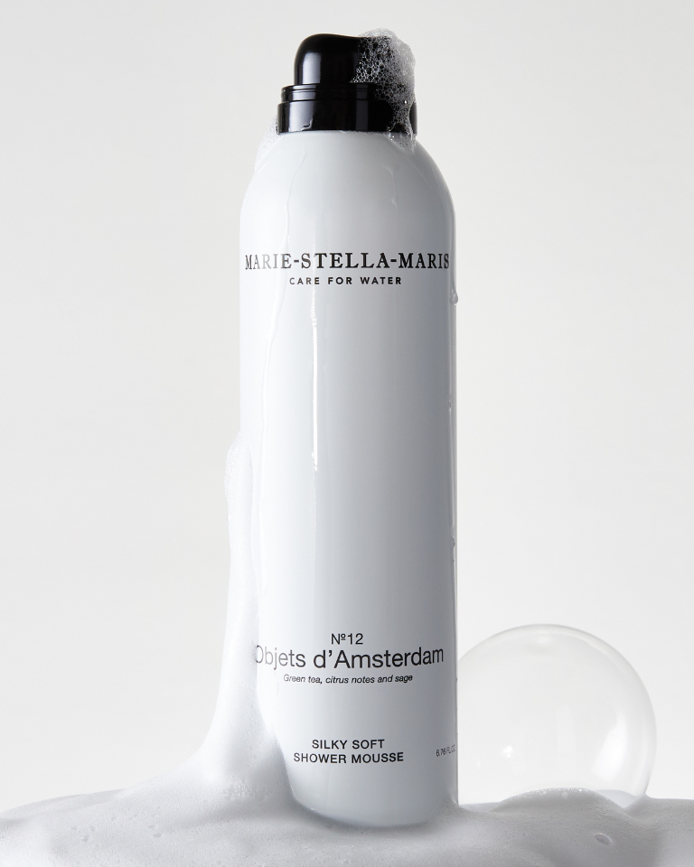 Marie-Stella-Maris Silky Soft Shower Mousse No.12 Objets d’Amsterdam surrounded by soft foam, featuring a sleek white bottle with notes of green tea, citrus notes and sage.