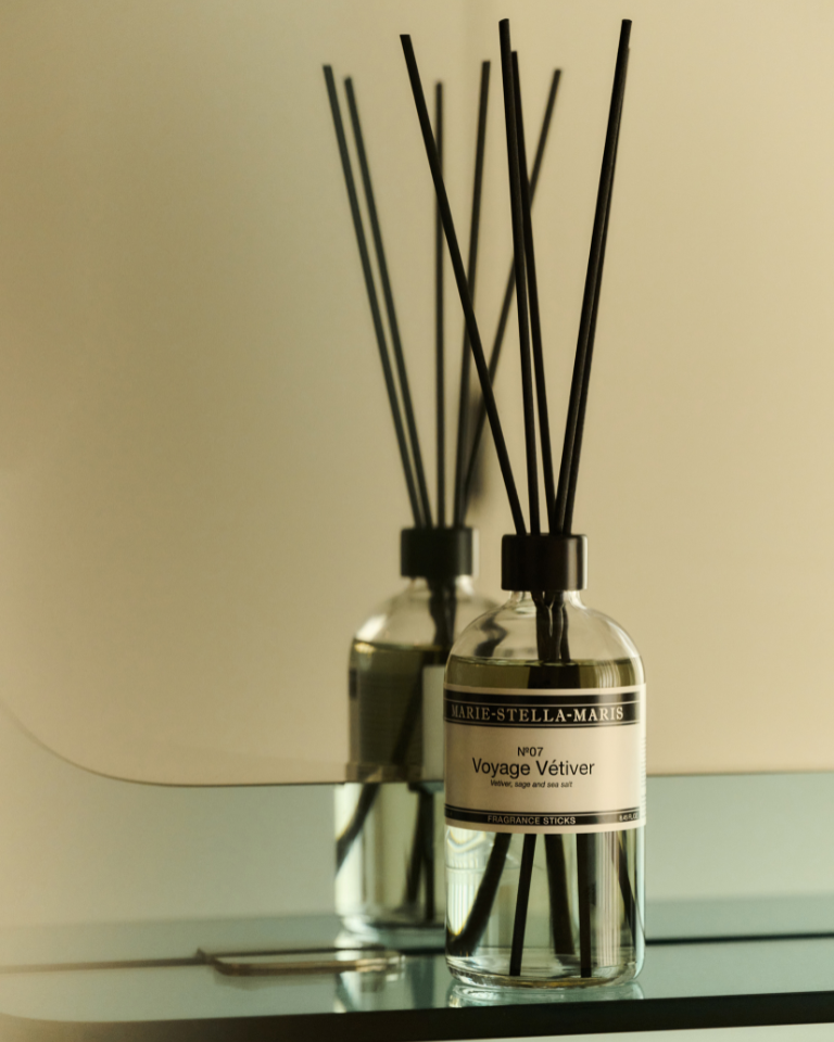 Marie-Stella-Maris No.13 L'Heure Santal Fragrance Sticks (250 ml) displayed on a marble mantelpiece beside a rustic ceramic vase. 
