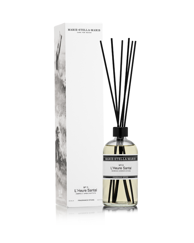 Marie-Stella-Maris Fragrance Sticks in No.13 L’Heure Santal, presented in a clear glass bottle with black fragrance reeds alongside its white product box. The signature fragrance features notes of sandalwood, cardamom and tonka, photographed against a clean white background.