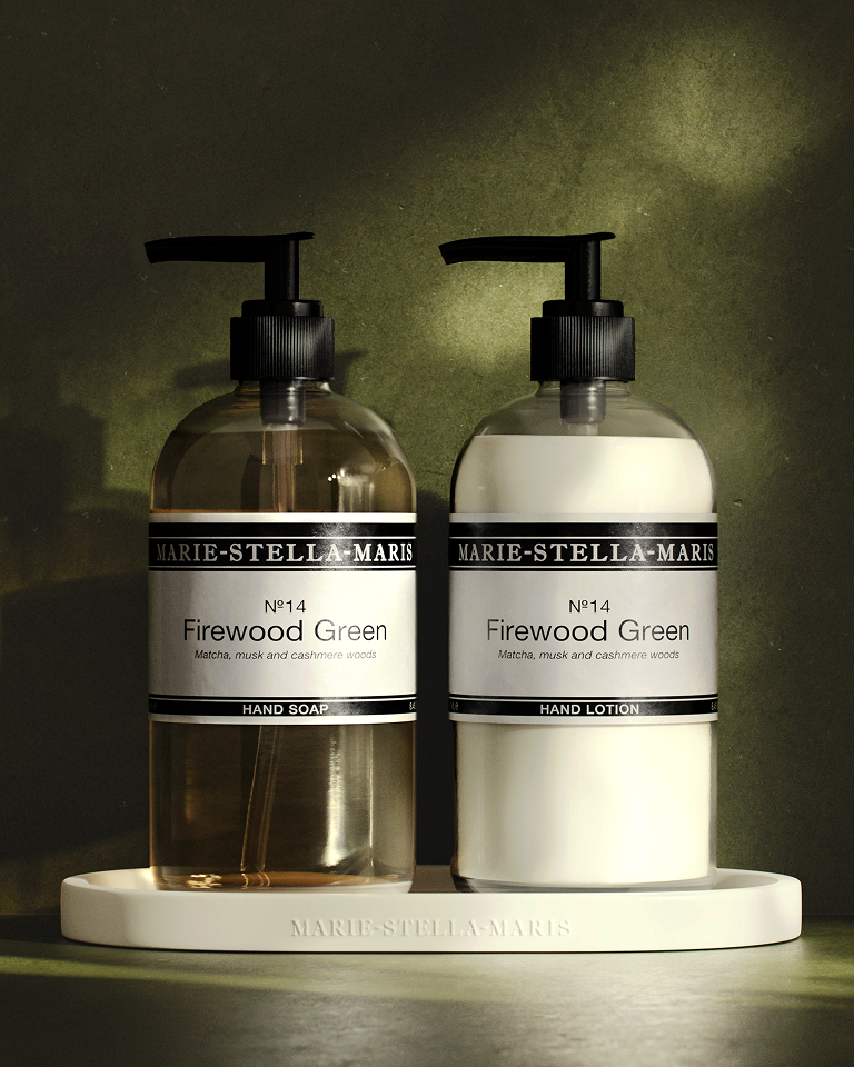 Marie-Stella-Maris No. 14 Firewood Green hand soap and hand lotion displayed on a white tray in atmospheric light, featuring notes of matcha, musk and cashmere woods.