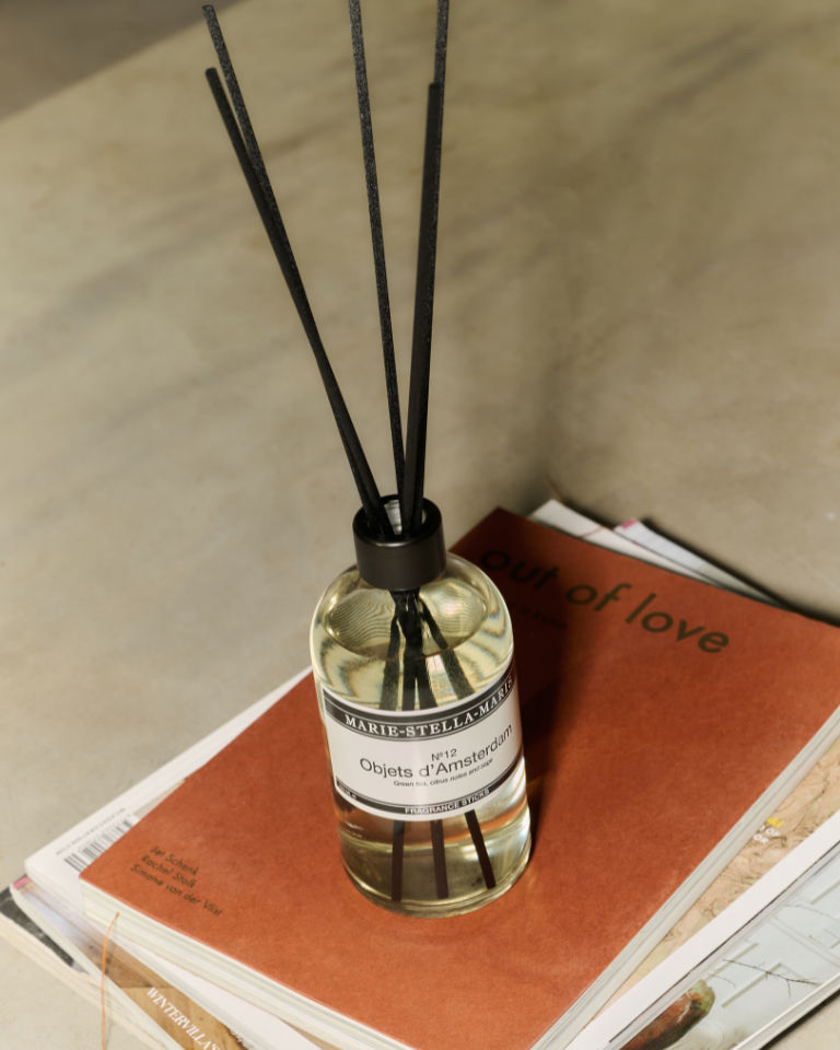 Marie-Stella-Maris Luxury Geurstokjes Objets d'Amsterdam diffuser 250 ml with green tea, citrus, and sage scent on magazines background