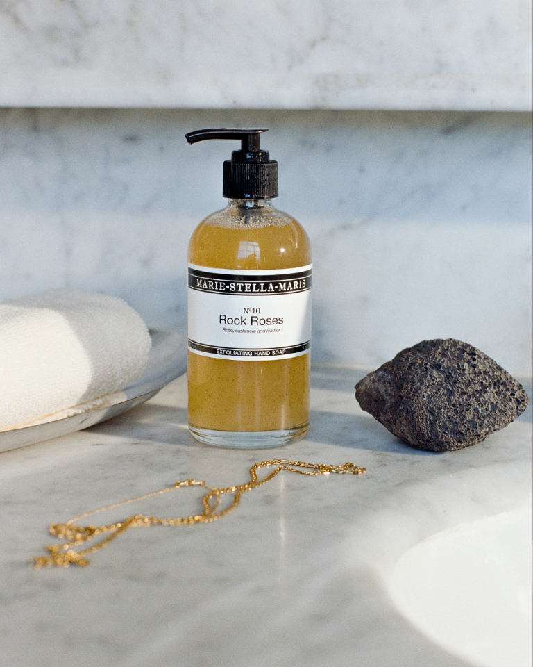 Marie-Stella-Maris No.10 Rock Roses exfoliating hand soap, styled on a marble surface with natural elements, creating an elegant, spa-like setting for the Mother’s Day campaign.