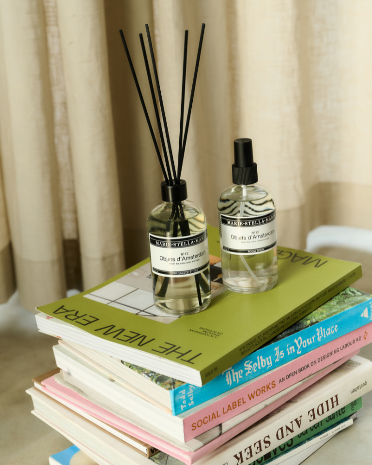 Marie-Stella-Maris No.12 Objets d'Amsterdam room spray 250 ml with a No.12 fragrance sticks 250 ml on a stack of colorful books