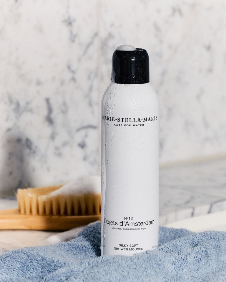 Marie-Stella-Maris Silky Soft Shower Mousse No.12 Objets d’Amsterdam 200 ml on a bathroom surface with a towel and brush in the background.
