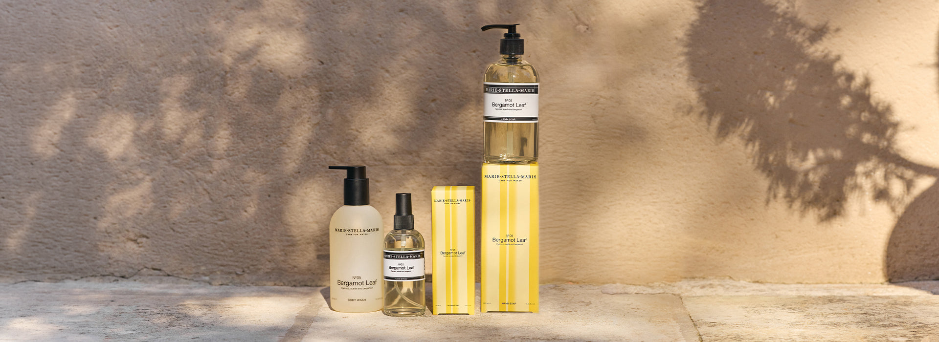 Marie-Stella-Maris No.05 Bergamot Leaf limited edition summer scent collection, featuring body wash, room spray, and hand soap with matching yellow-striped packaging, styled in a warm sunlit setting.