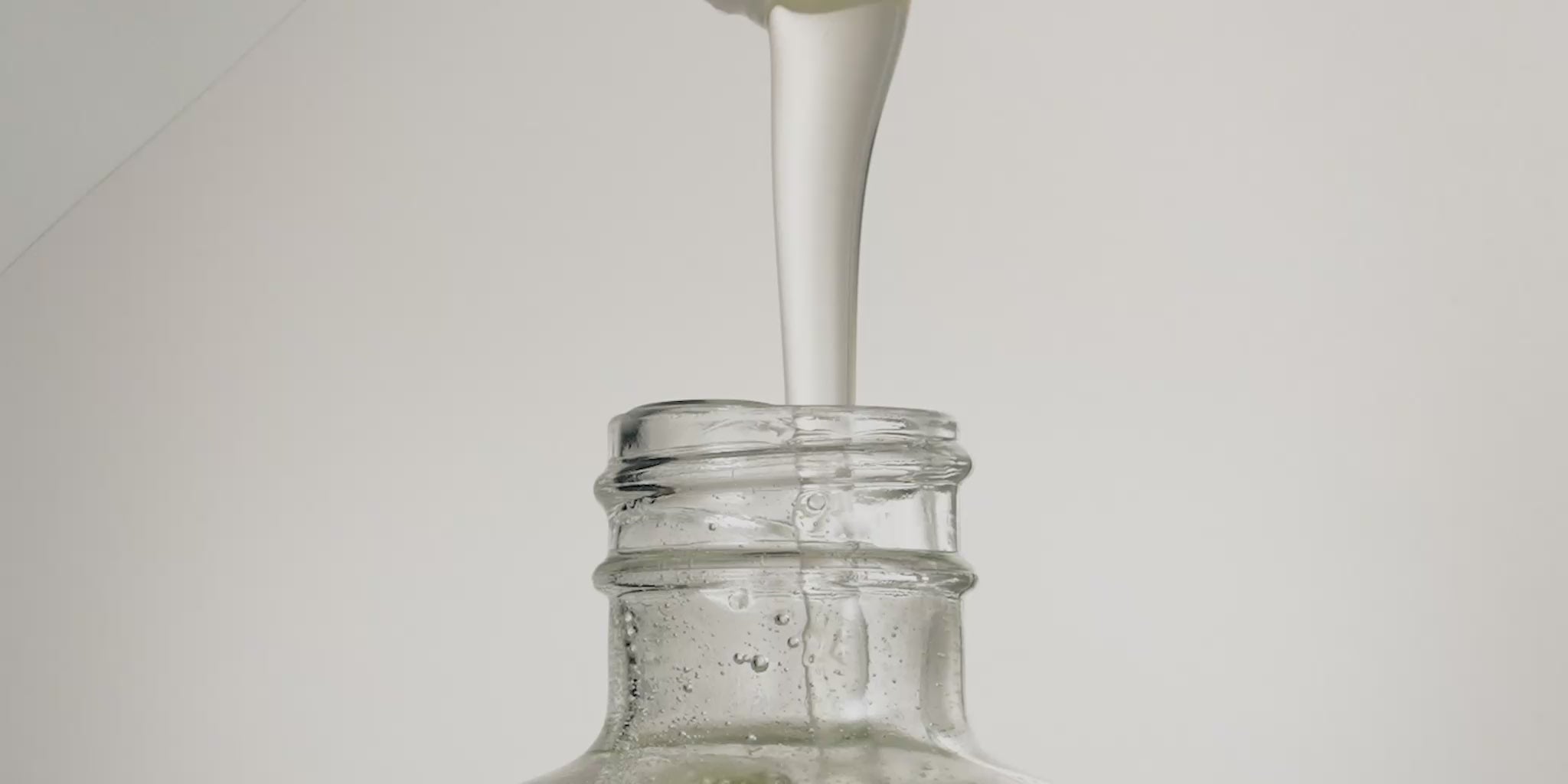 Close-up video of a Marie-Stella-Maris refill being poured into a reusable glass hand soap bottle. A smooth stream of liquid flows into the bottle against a clean, neutral background, illustrating the Marie-Stella-Maris refill subscription and the ease of replenishing hand soap at home with less packaging waste.