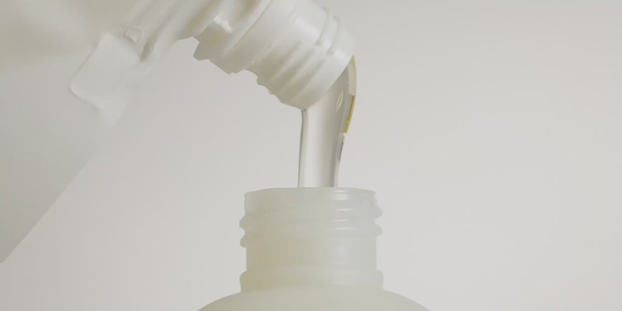 Close-up video of a Marie-Stella-Maris refill pouch pouring liquid hand soap into a reusable Marie-Stella-Maris bottle. The clear soap flows smoothly into the bottle opening against a soft white background, highlighting the brand’s refillable packaging and sustainable home care concept.